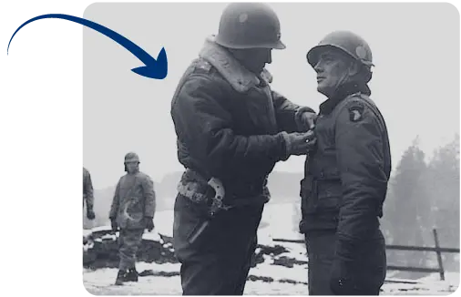 Brigadier General Anthony McAuliffe is decorated by Patton with the Distinguished Service Cross for the defence of Bastogne. Brigadier General Anthony McAuliffe is decorated by Patton with the Distinguished Service Cross for the defence of Bastogne.